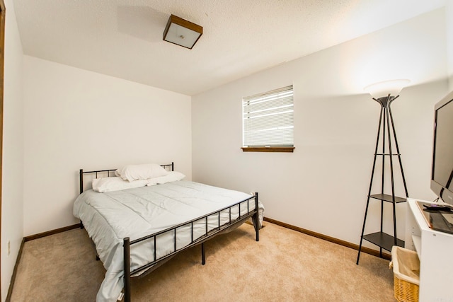 bedroom with light carpet and a textured ceiling