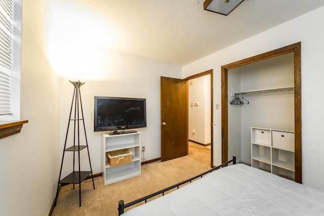 bedroom featuring a closet, a textured ceiling, and light colored carpet