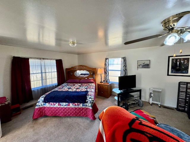 carpeted bedroom featuring radiator and ceiling fan