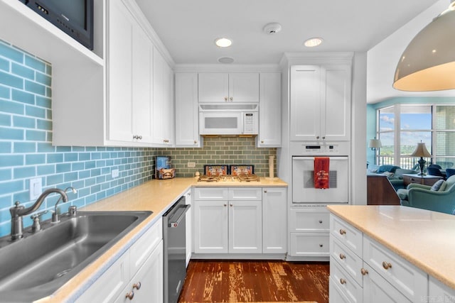 kitchen with white appliances, sink, backsplash, dark hardwood / wood-style flooring, and white cabinetry