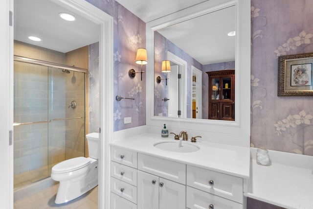 bathroom with vanity, toilet, tile patterned flooring, and an enclosed shower