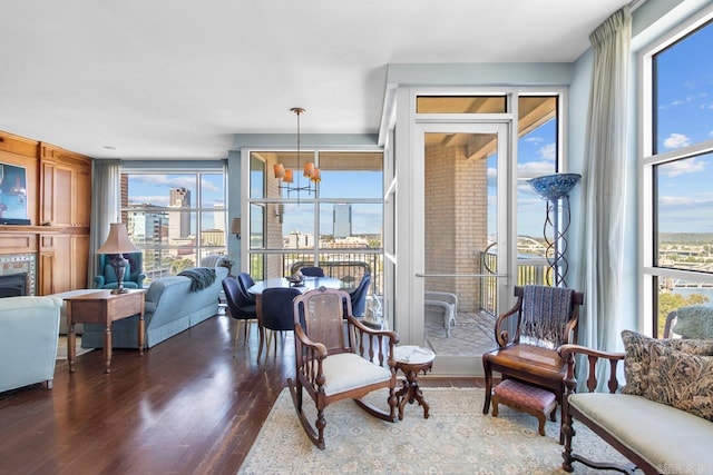 interior space with a wealth of natural light, an inviting chandelier, and dark hardwood / wood-style flooring