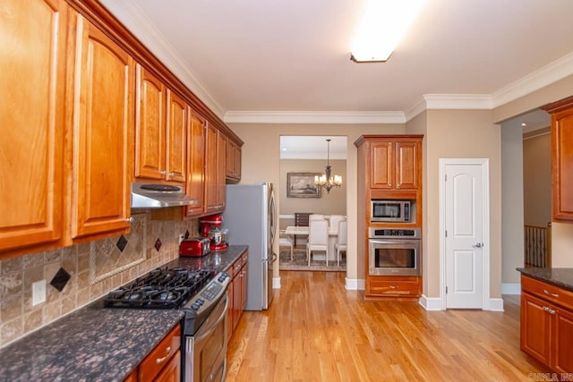 kitchen featuring appliances with stainless steel finishes, light wood-type flooring, ornamental molding, decorative backsplash, and an inviting chandelier