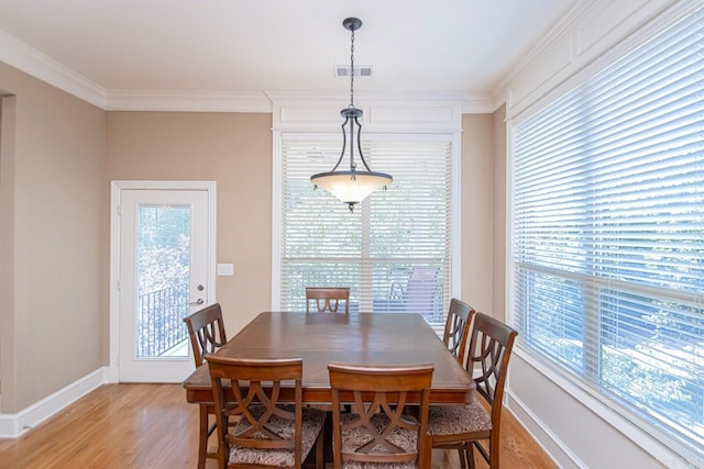 dining area featuring crown molding and light wood-type flooring