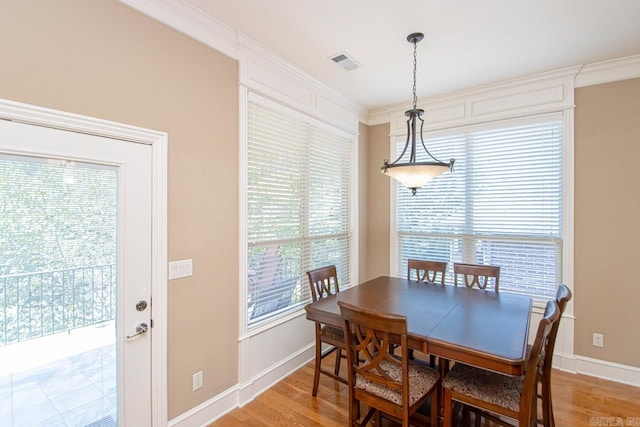 dining room with hardwood / wood-style floors and crown molding