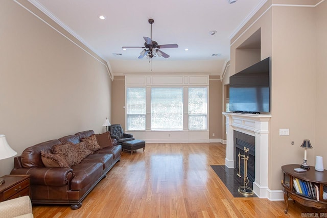 living room featuring ornamental molding, light hardwood / wood-style flooring, and ceiling fan