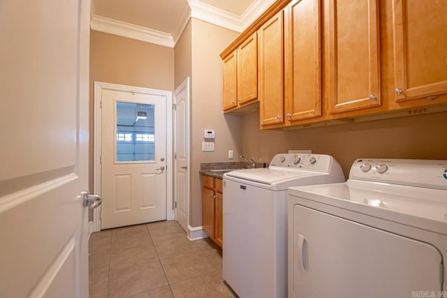 laundry area featuring crown molding, light tile patterned flooring, washing machine and dryer, and cabinets