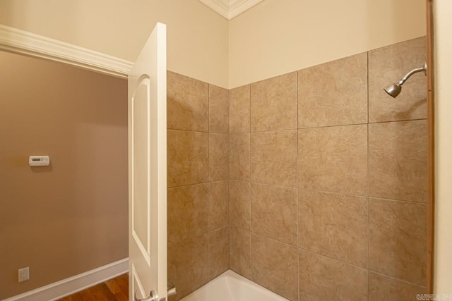 bathroom featuring hardwood / wood-style floors, tiled shower / bath combo, and crown molding