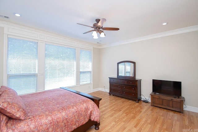 bedroom with ceiling fan, crown molding, multiple windows, and light wood-type flooring