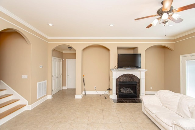 living room featuring ceiling fan, ornamental molding, light tile patterned flooring, and a high end fireplace