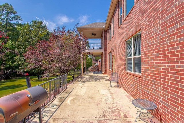 view of patio featuring ceiling fan and a balcony