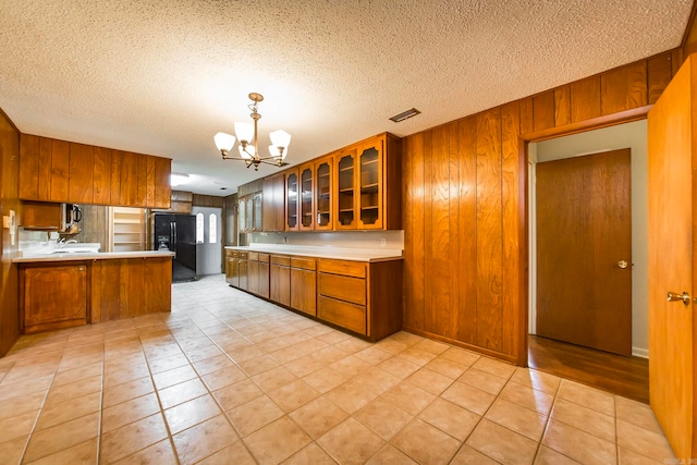 kitchen featuring black refrigerator with ice dispenser and a textured ceiling