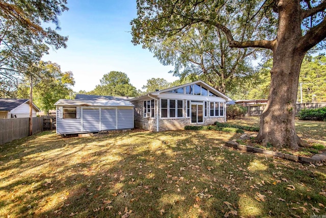 rear view of house with a sunroom and a lawn