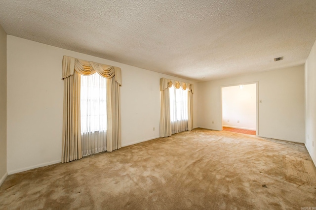 carpeted spare room featuring a textured ceiling