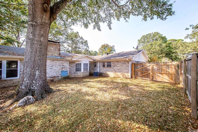 back of property with a yard and central AC unit