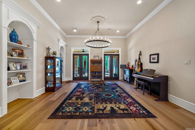 foyer with french doors, crown molding, wood-type flooring, and a chandelier