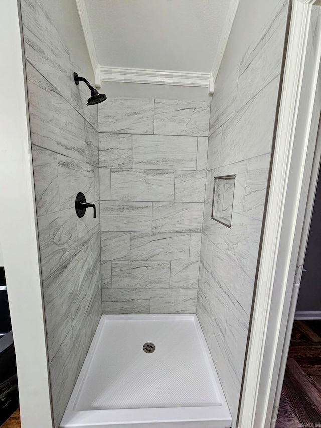 bathroom featuring a stall shower and crown molding