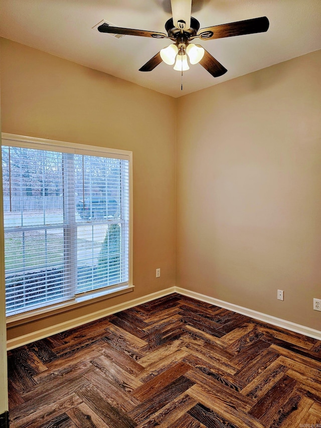 empty room with ceiling fan and baseboards