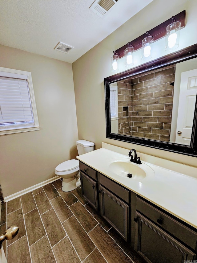 full bathroom with wood tiled floor, visible vents, vanity, and toilet