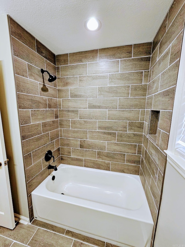 full bathroom with a textured ceiling and shower / tub combination