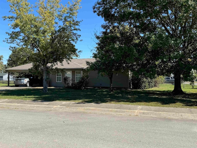 view of front of home with a front yard and a carport