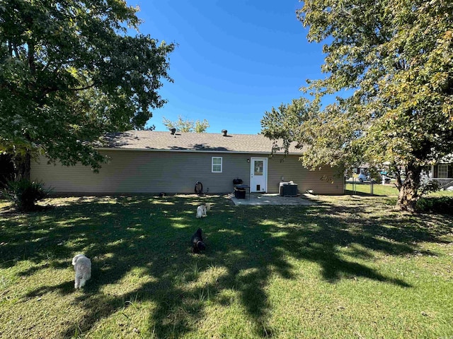 rear view of house with a yard, cooling unit, and a patio area