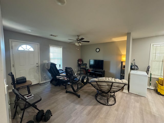 living room with light hardwood / wood-style floors and ceiling fan