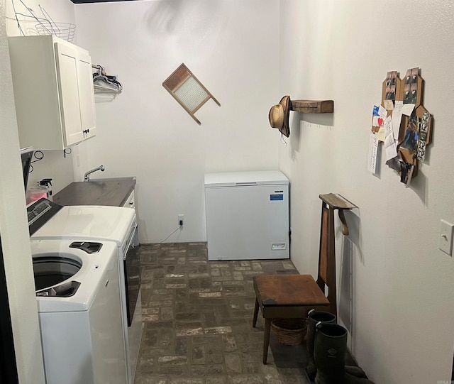 clothes washing area with independent washer and dryer and cabinets