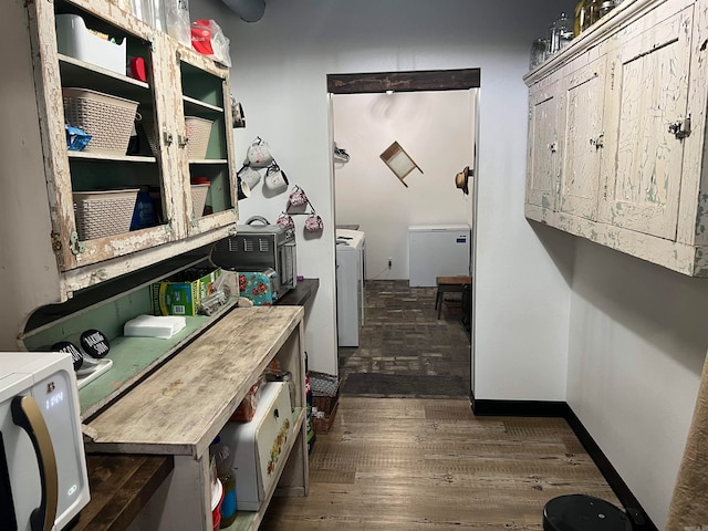 laundry room with washing machine and clothes dryer and dark hardwood / wood-style floors