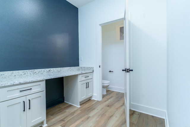 bathroom featuring vanity, wood finished floors, toilet, and baseboards