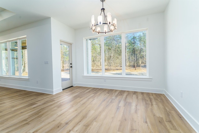 unfurnished dining area with light wood-style flooring, baseboards, and a wealth of natural light