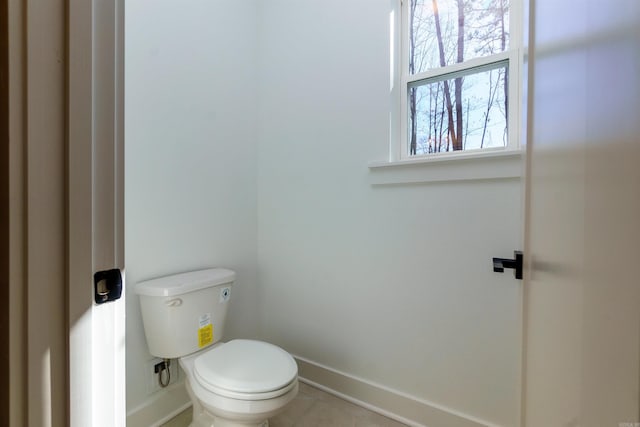 bathroom with baseboards and toilet