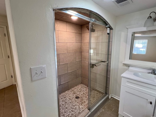 bathroom with vanity, tile patterned flooring, and a shower with door