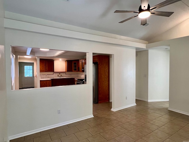 interior space with tile patterned floors, a raised ceiling, and ceiling fan