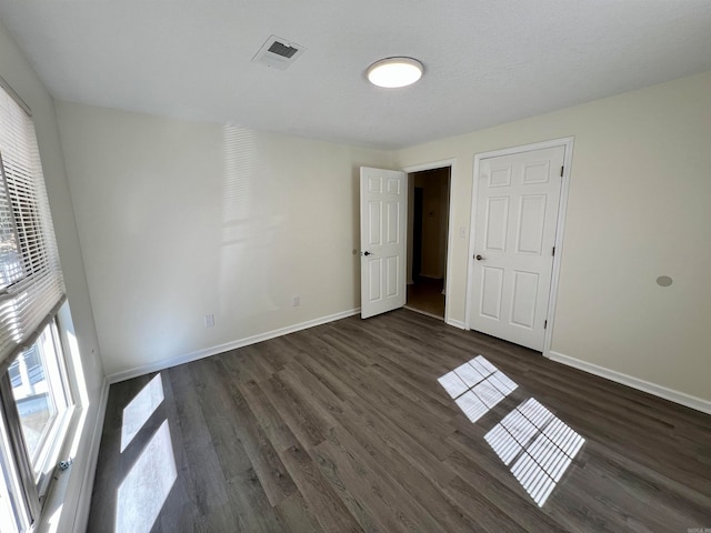 unfurnished room with dark wood-type flooring and a textured ceiling