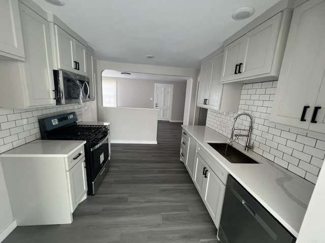 kitchen with appliances with stainless steel finishes, sink, dark hardwood / wood-style floors, and white cabinets