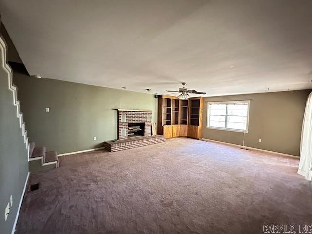 unfurnished living room featuring ceiling fan, carpet floors, and a fireplace