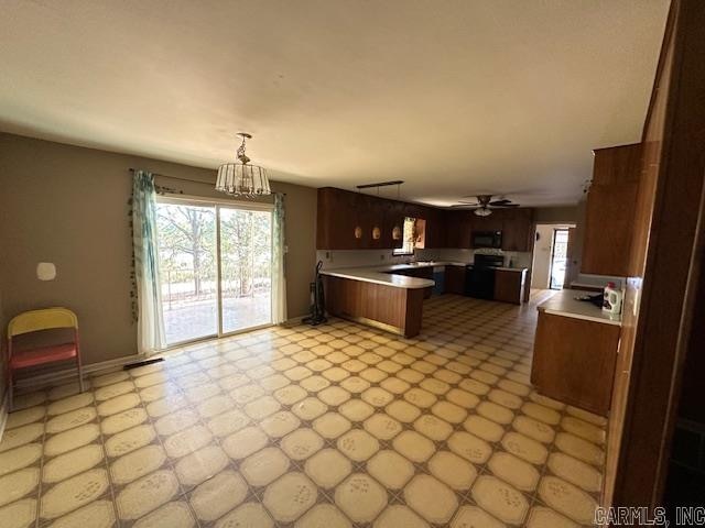 kitchen with black appliances, decorative light fixtures, kitchen peninsula, and ceiling fan with notable chandelier