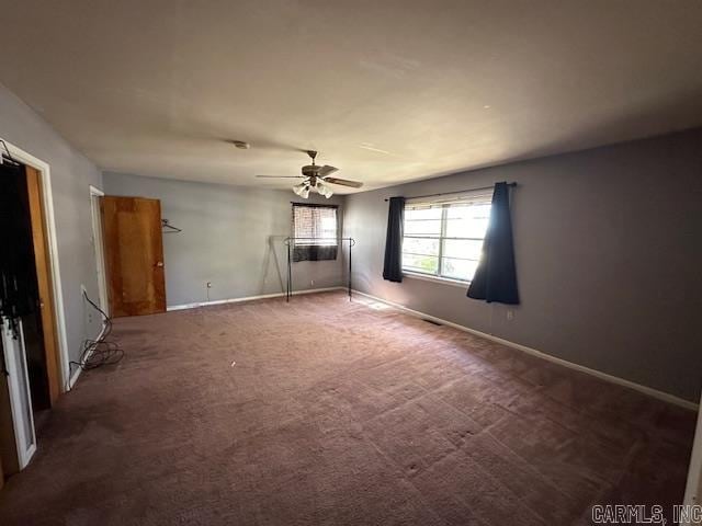 carpeted spare room featuring ceiling fan