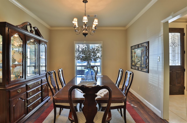 dining room with ornamental molding, wood-type flooring, and an inviting chandelier