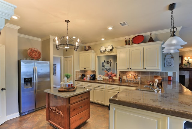 kitchen with kitchen peninsula, stainless steel fridge, backsplash, and pendant lighting