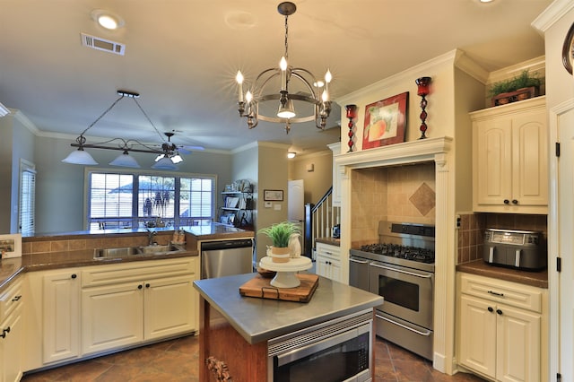 kitchen with sink, backsplash, stainless steel appliances, pendant lighting, and ornamental molding