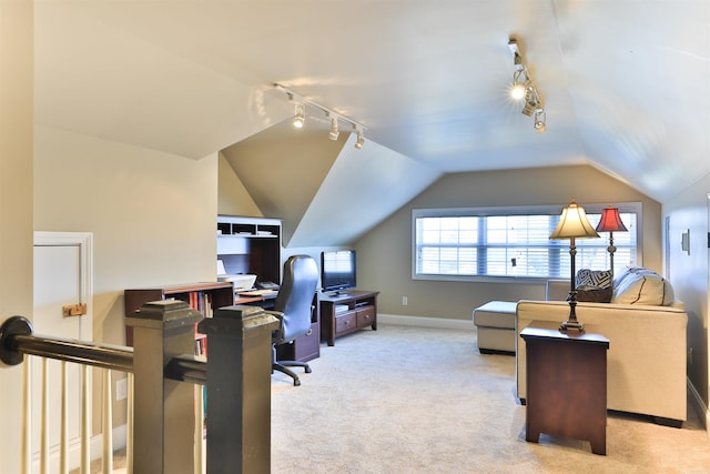 carpeted home office featuring rail lighting, lofted ceiling, and baseboards