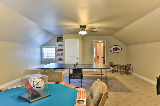 recreation room featuring light colored carpet, a ceiling fan, vaulted ceiling, and baseboards