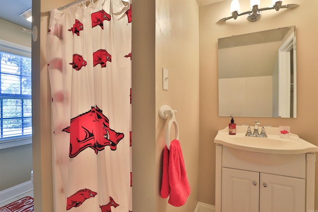 bathroom featuring a shower with curtain, vanity, and baseboards
