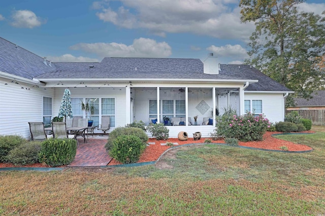 rear view of house with a yard and a patio area