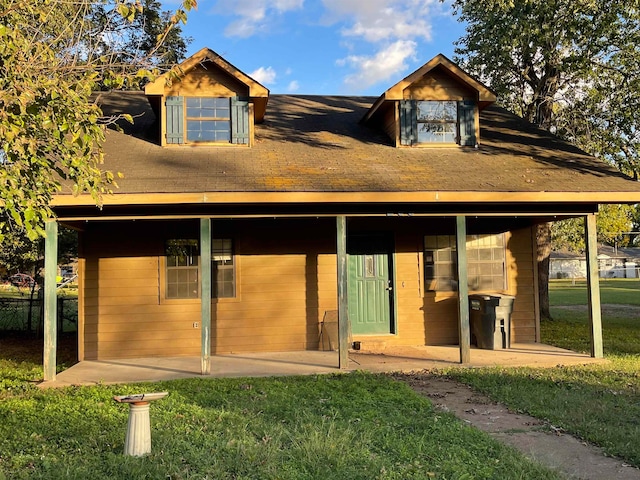 back of property featuring a patio and a yard