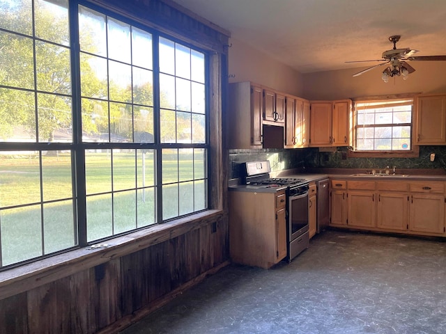 kitchen featuring appliances with stainless steel finishes, decorative backsplash, sink, and ceiling fan