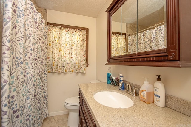 bathroom with vanity, toilet, a textured ceiling, and curtained shower