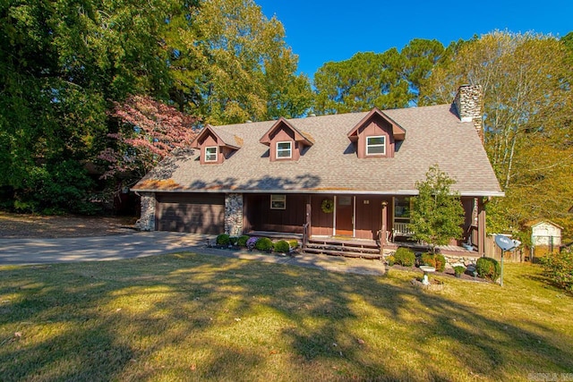 cape cod-style house featuring a front yard, covered porch, and a garage